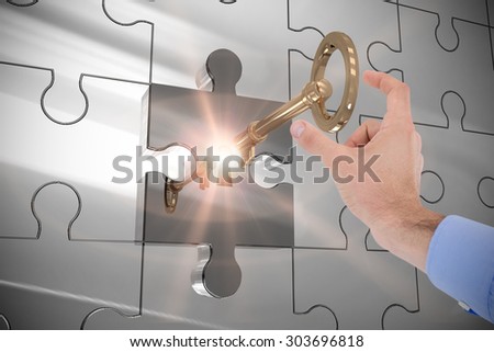 Businessman holding hand out in presentation against key unlocking jigsaw