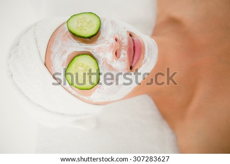 Relaxed woman with cucumber on a creamed face at the health spa