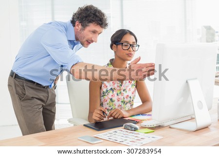 Casual business couple using computer in a bright office