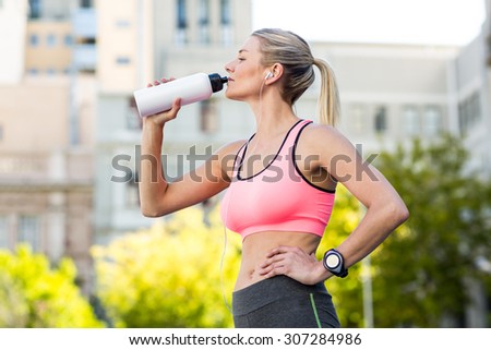 A beautiful woman drinking water on a sunny day