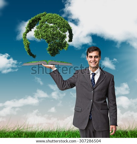 Man holding up lawn book against green field under blue sky