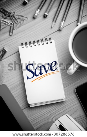 The word save against notepad on desk