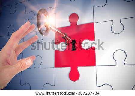 Businesswoman showing with his hand against key unlocking jigsaw