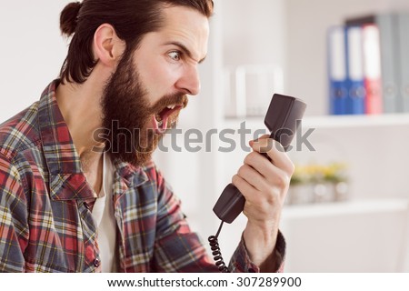 Hipster angry businessman making a call in his office