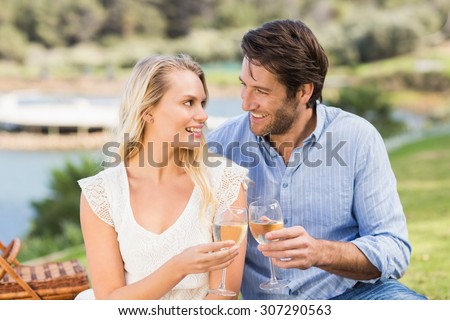 Cute couple on date toasting with glass of white wine