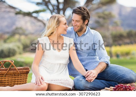 Couple on date looking at each other lying on a blanket