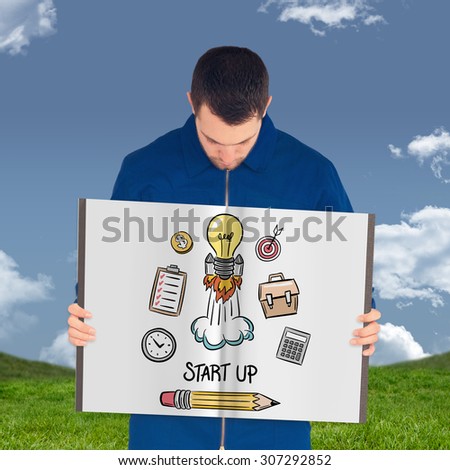 Manual worker showing a book against grass and sky