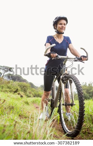 Athletic blonde sitting on mountain bike in the nature