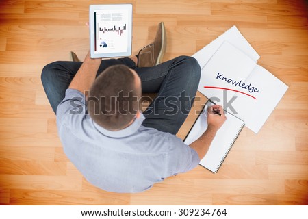 The word knowledge and business graphs against young creative businessman looking at tablet