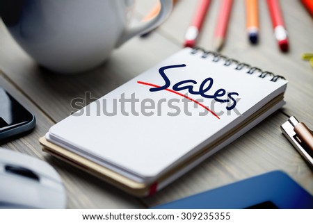 The word sales against notepad on desk