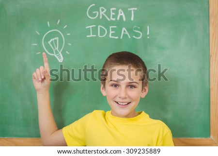 Portrait of smiling pupil pointing on chalkboard in a classroom in school