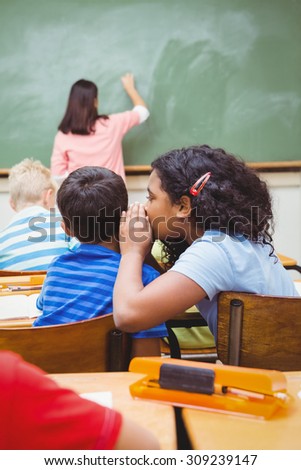 Student whispering into another students ear at the elementary school
