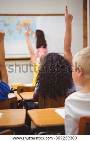 Students raising hands to answer a question at the elementary school