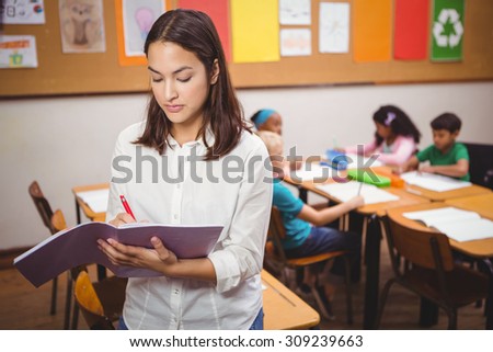 Teacher correcting some class work at the elementary school