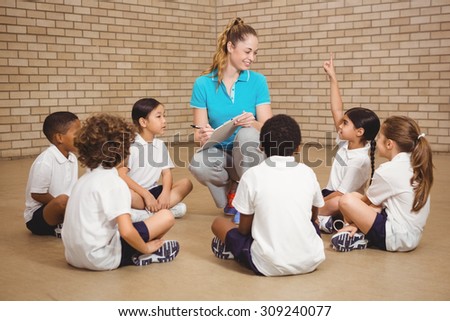 Students sitting and listening to the teacher at the elementary school
