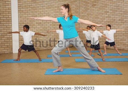 Students and teacher doing yoga pose at elementary school