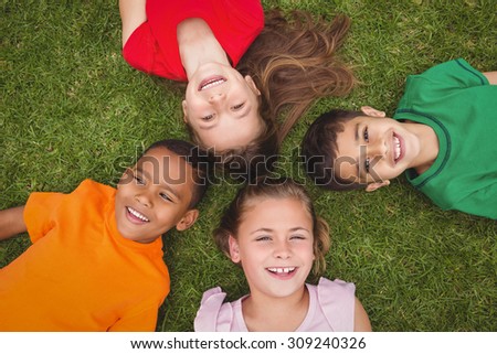 Smiling pupils lying on the ground looking at the camera