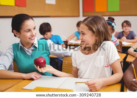 Pupil offering an apple to teacher at the elementary school