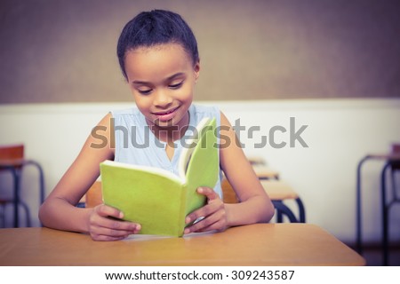 Smiling student reading a book at the elementary school