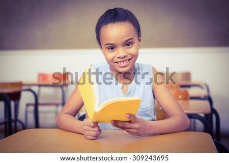 Smiling student reading a book at the elementary school
