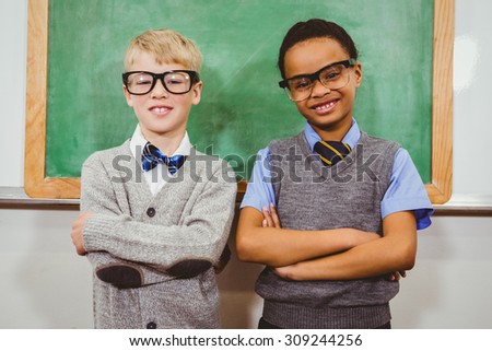 Smart students standing in front of a blackboard at the elementary school