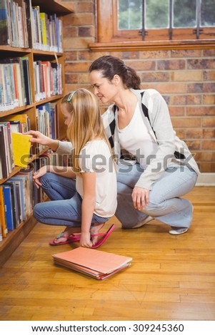 Teacher helping a student pick a book at the elementary school