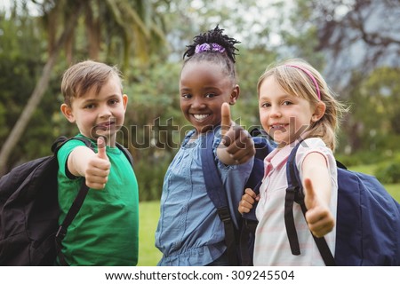 Happy Students wearing school bags on the elementary school grounds