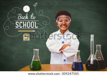 Cute pupil dressed up as scientist against green chalkboard