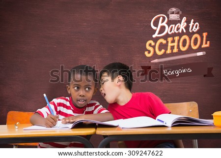 Cute pupils writing at desk in classroom against desk