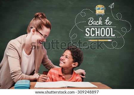 Teacher helping pupil against green chalkboard