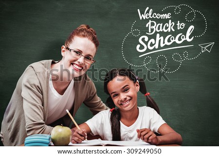 Happy pupil and teacher against green chalkboard