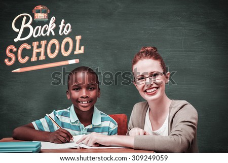 Happy pupil and teacher against green chalkboard