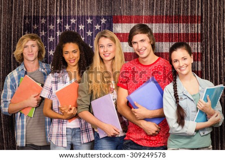 College students holding books in library against composite image of usa national flag