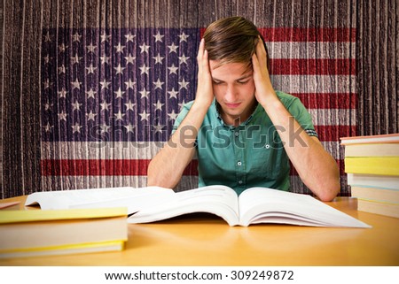 Student sitting in library reading against composite image of usa national flag