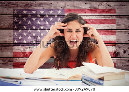 Student goes crazy doing her homework against composite image of usa national flag