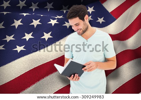 Student reading book against digitally generated american national flag