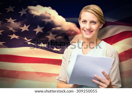 Smiling teacher against composite image of digitally generated american flag rippling