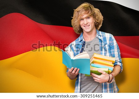 Student reading book against digitally generated german national flag