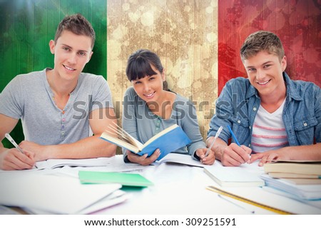 Students doing work together as they all look into the camera against italy flag in grunge effect
