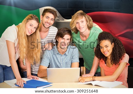 College students using laptop in library against italy flag waving