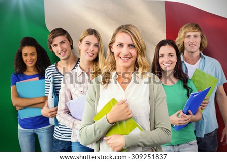 College students holding folders at college against digitally generated italian national flag