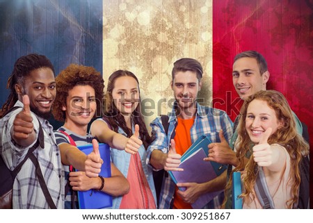 Smiling group of students doing thumbs up against france flag in grunge effect