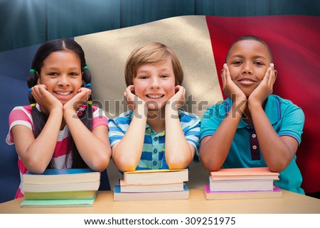 Cute pupils looking at camera in library against digitally generated france national flag