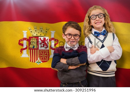 Cute pupils looking at camera against digitally generated spanish national flag