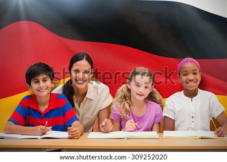 Pretty teacher helping pupils in library against digitally generated german national flag