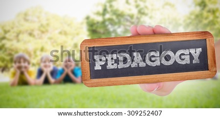 The word pedagogy and hand showing chalkboard against happy friends in the park