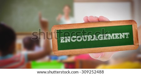 The word encouragement and hand showing chalkboard against pupils raising their hands during class