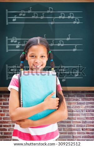 Cute pupil smiling at camera in library against teal, blue