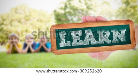 The word learn and hand showing chalkboard against happy friends in the park