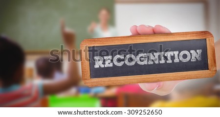 The word recognition and hand showing chalkboard against pupils raising their hands during class